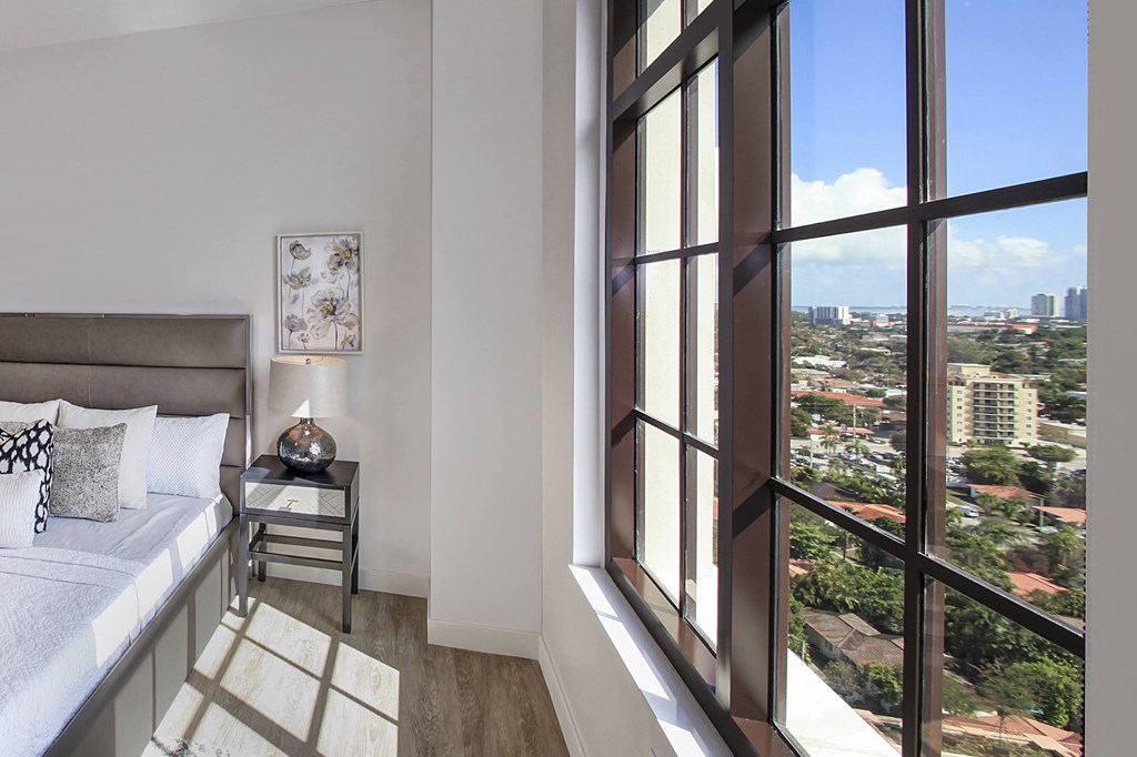 a bedroom with a bed and a window overlooking a city