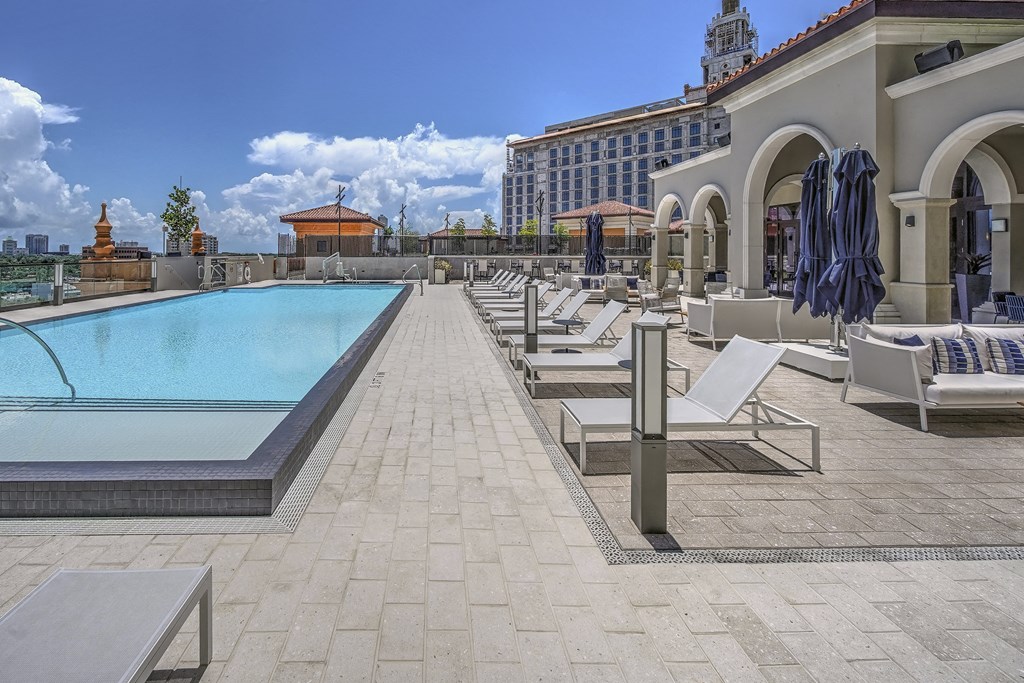 a pool and lounge area on the rooftop of a hotel
