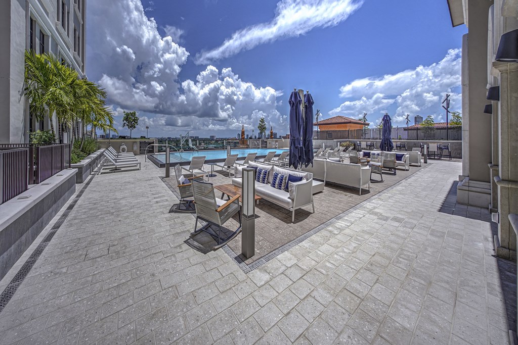 an outdoor patio with tables and chairs and a pool