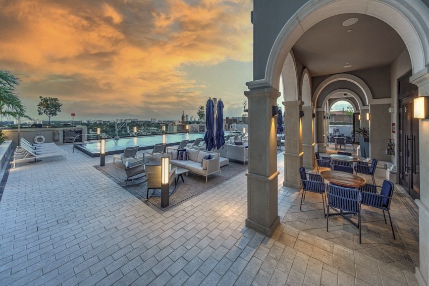 a rooftop patio with tables and chairs and a view of the city