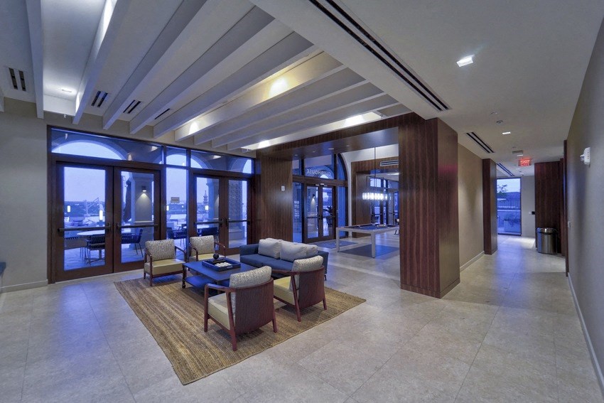 a lobby of a building with couches and chairs and a large window