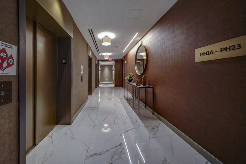 a hallway with a white marble floor and brown walls and a door