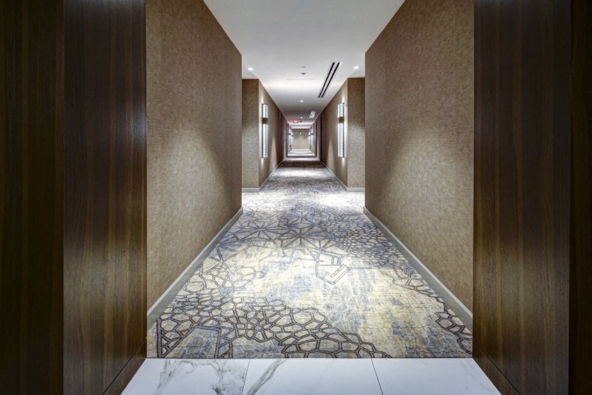 a long hallway with marble flooring and wooden walls