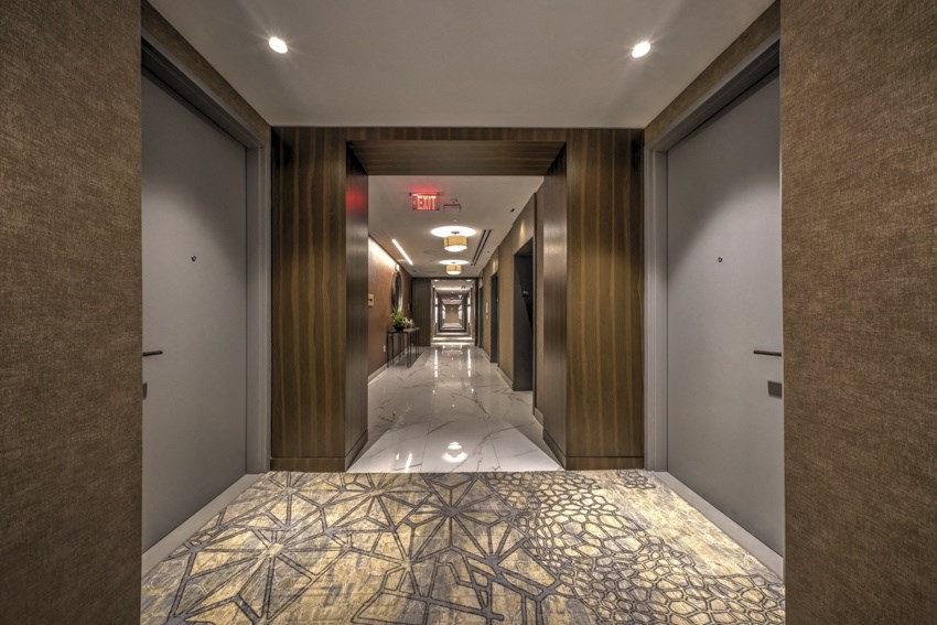 a long hallway with a patterned carpet and doors