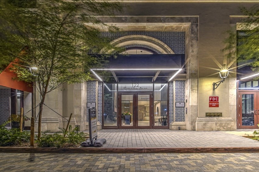 a night view of the entrance to a building with a door open