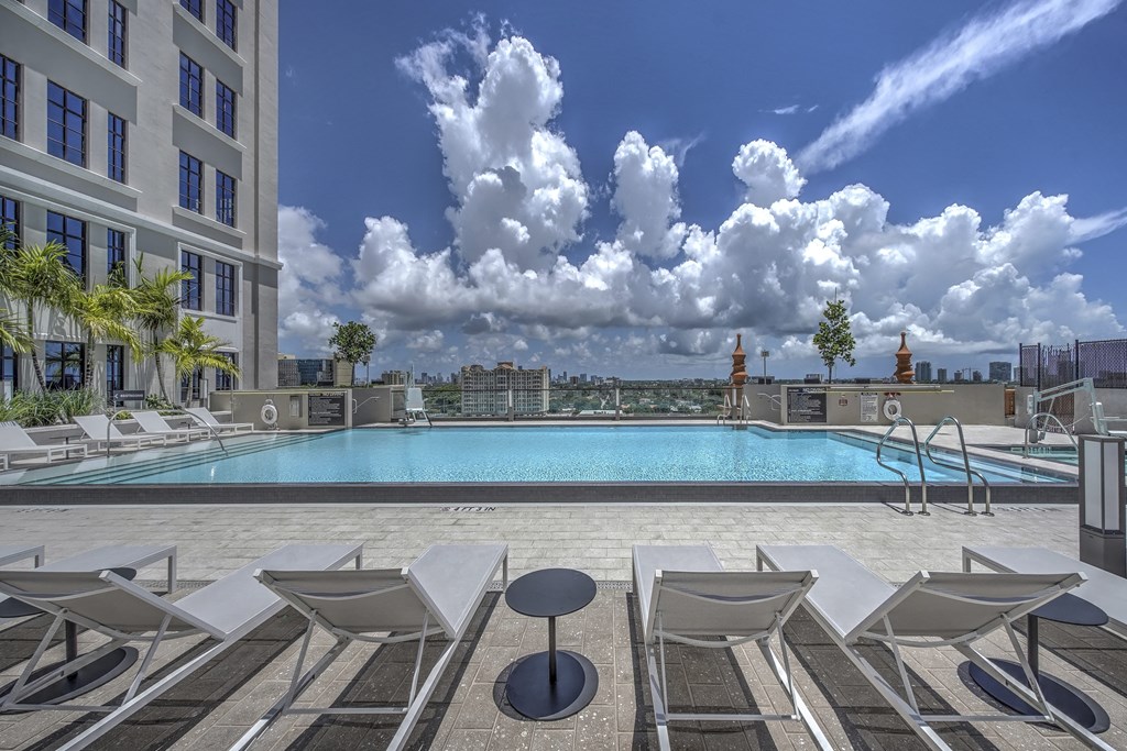 a swimming pool on the rooftop of a building with a city in the background