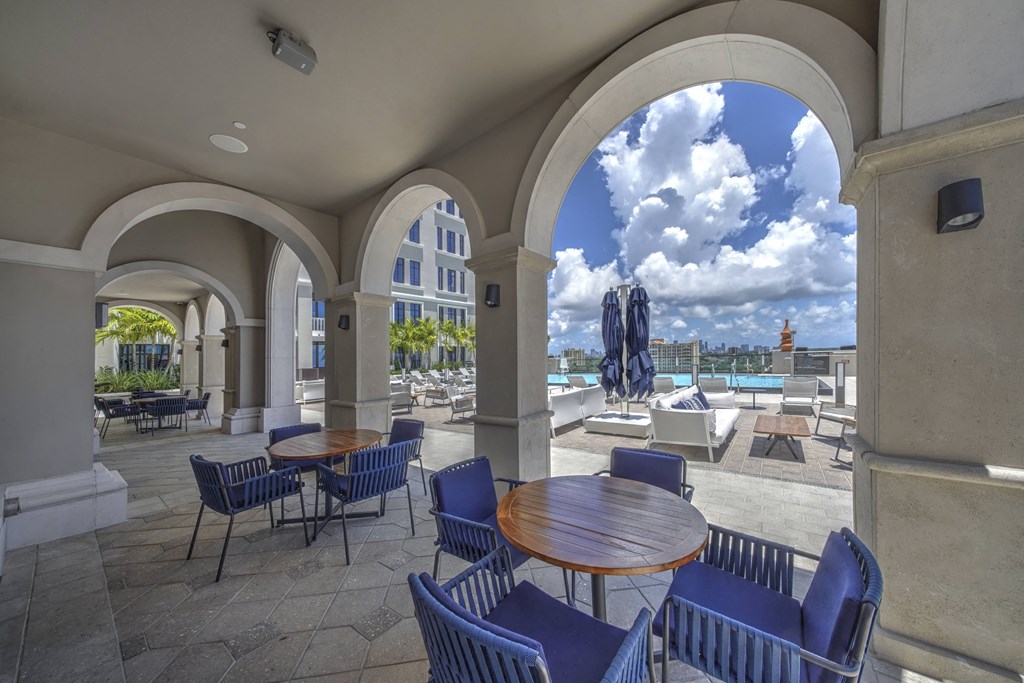 a patio with tables and chairs and a swimming pool