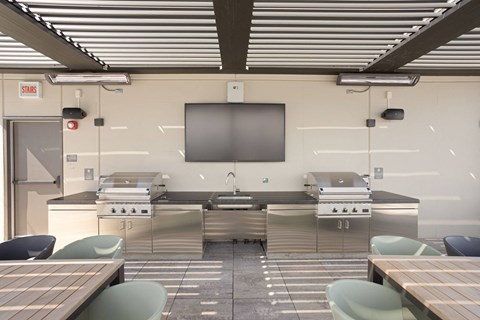a large commercial kitchen with tables and sinks and a tv