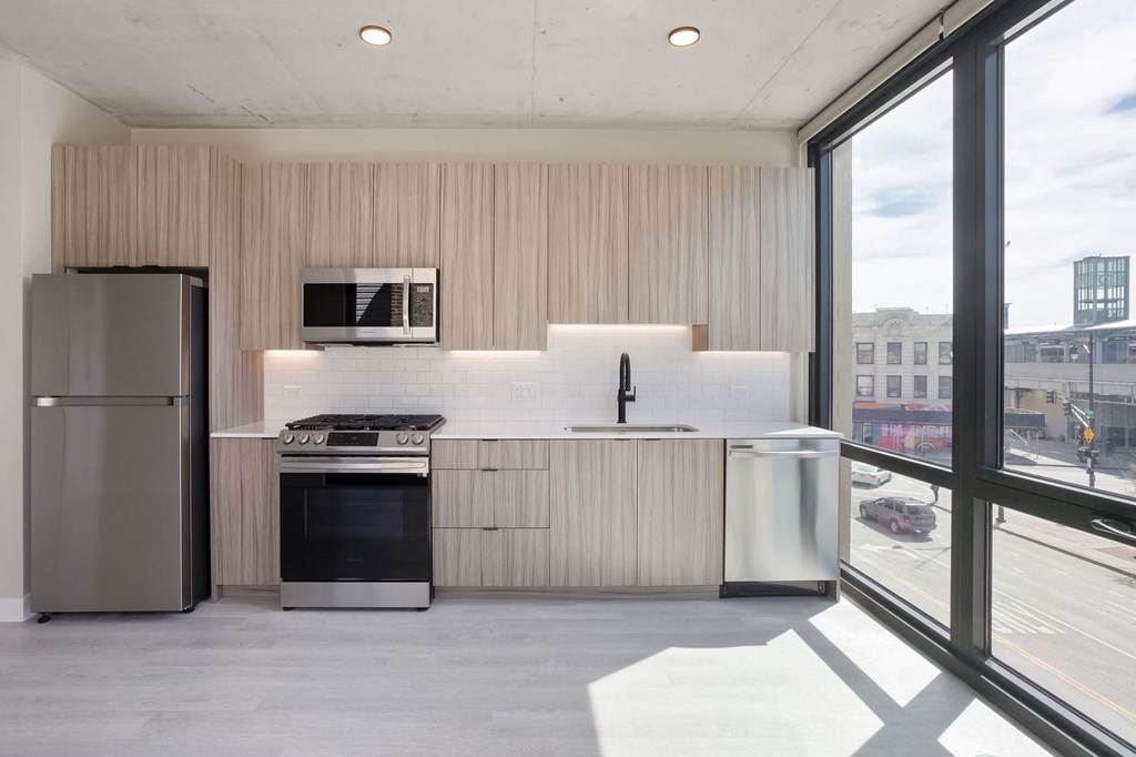 a kitchen with a refrigerator freezer and a stove top oven at Platform 4611, Chicago, IL