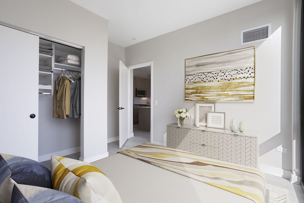 a bedroom with grey walls and a large bed with a yellow and white striped blanket at Platform 4611, Chicago, 60640