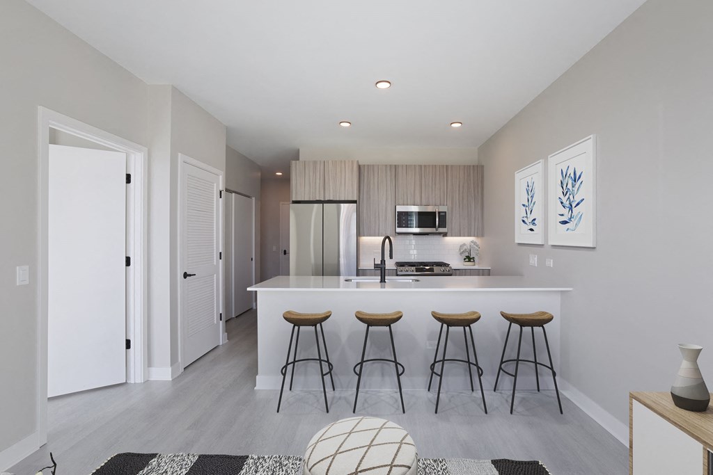 a kitchen with a large island with three stools in front of it at Platform 4611, Chicago, IL