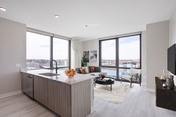 a kitchen with an island and a living room with a couch and a tv at Platform 4611, Chicago, 60640