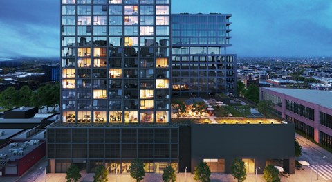 A modern glass building with a black building in front of it.