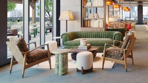 A living room with a green sofa, two chairs and a table.
