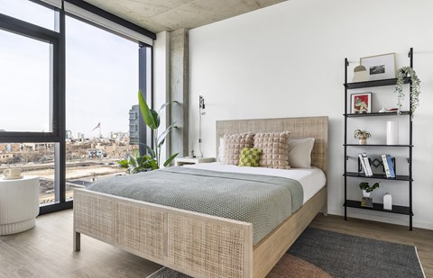 a bedroom with a bed and a large window