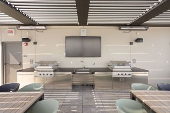 Outdoor cooking area with two high end grills and large TV at Platform 4611, Chicago