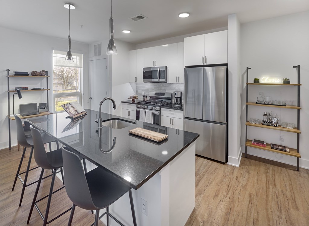 A modern kitchen with a black granite countertop and stainless steel appliances.