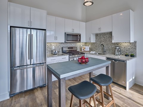 A kitchen with a table and chairs.