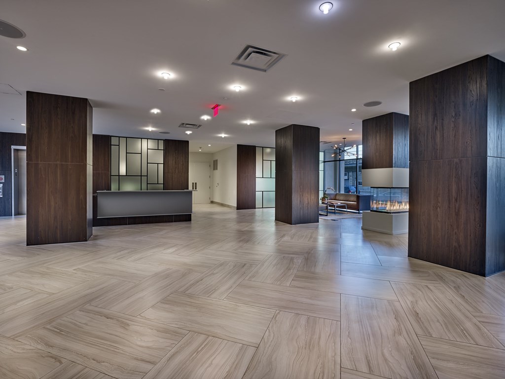 A spacious lobby with wooden floors and a reception desk.