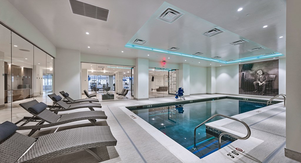 a swimming pool in the middle of a room with chairs