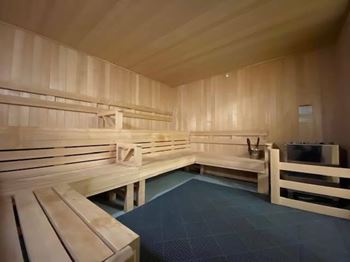 A sauna room with wooden benches and a stone floor.