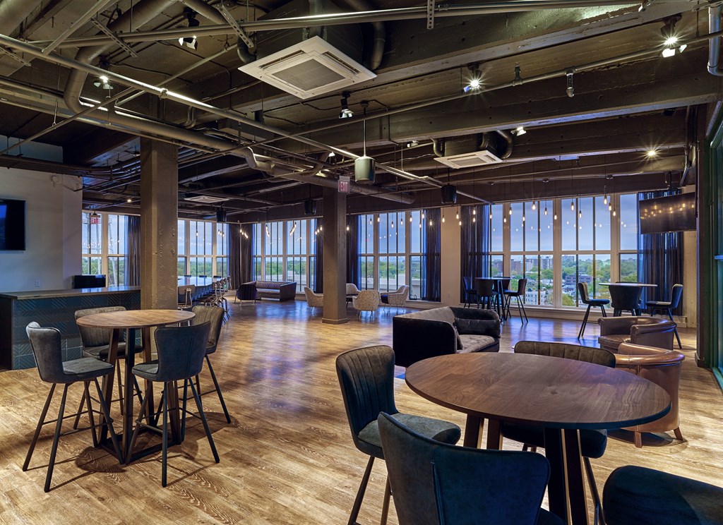 a large room with tables and chairs and windows