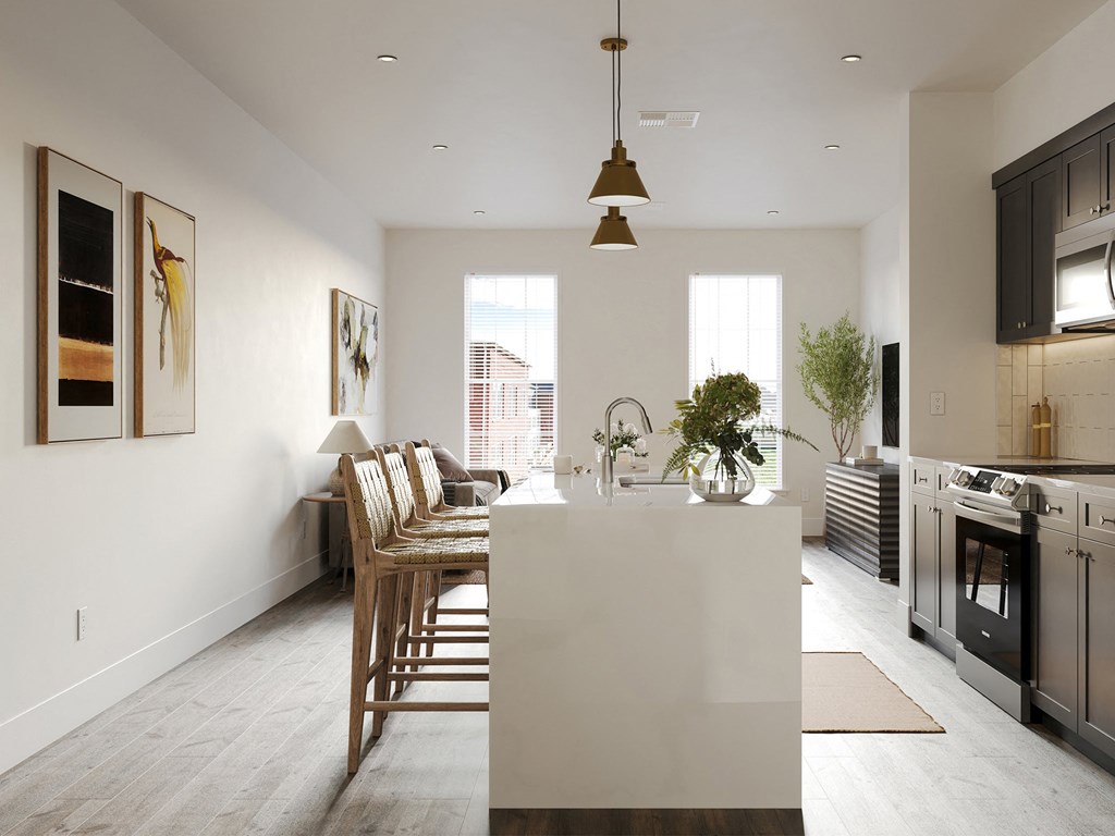 a kitchen and living room with a white island and a dining room table