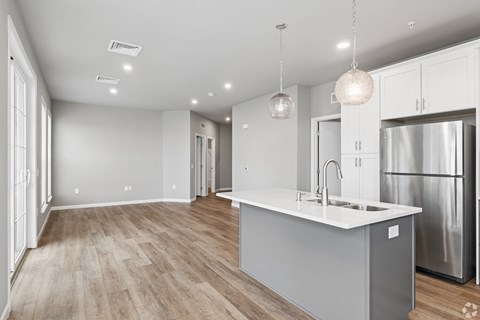 A modern kitchen with a stainless steel refrigerator and a center island.