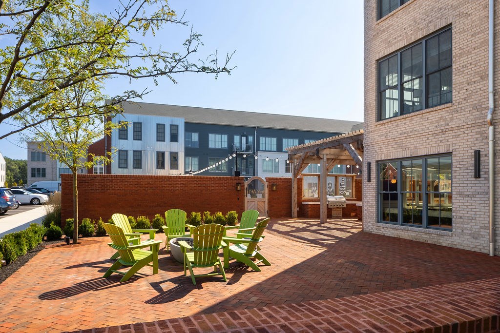 A patio with a table and chairs is in front of a building.