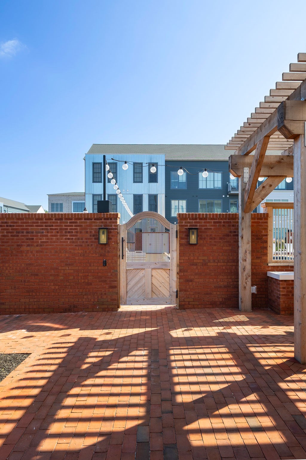 A blue building with a white door and a wooden pergola.