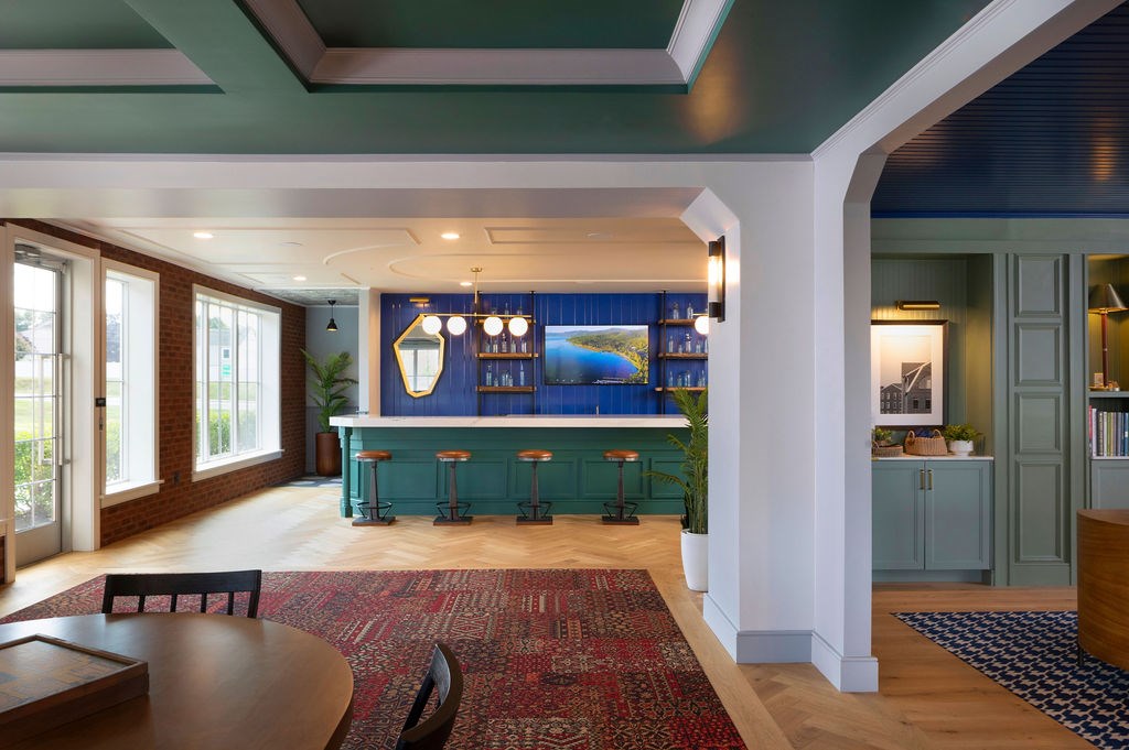 A room with a blue bar and a red rug.