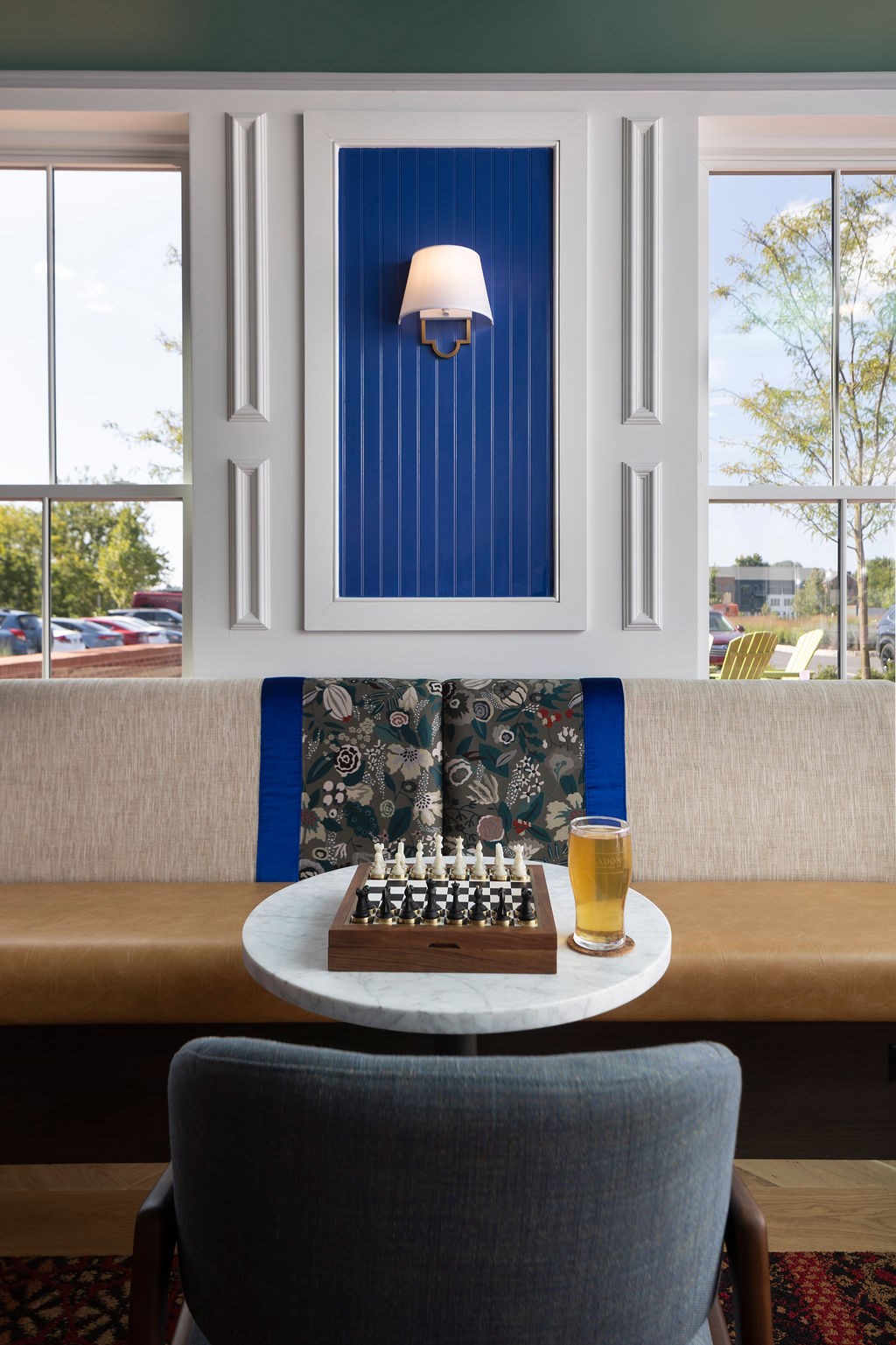 A blue and white framed picture with a lit candle on a table.