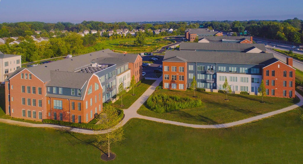 A large building complex with a green lawn in front.