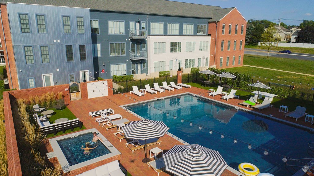 A large swimming pool surrounded by lounge chairs and umbrellas.