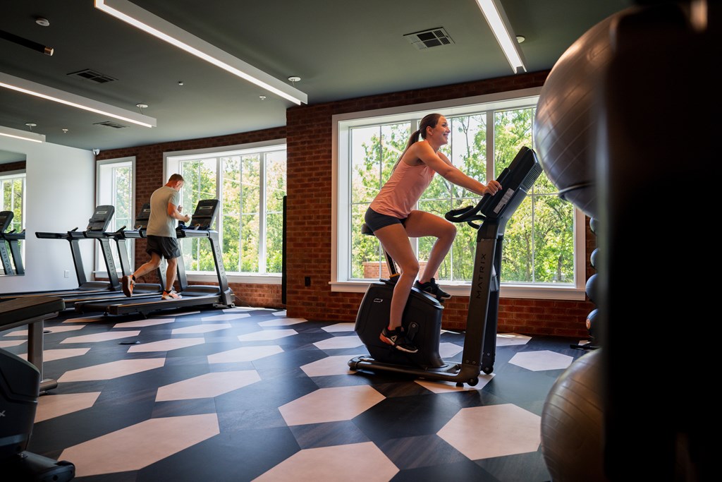 A woman is exercising on a treadmill in a gym.