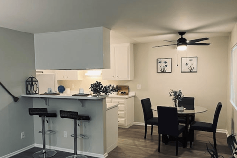 A kitchen with a bar and a dining table.