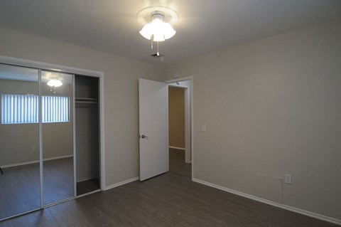 a bedroom with a mirrored closet and a ceiling fan
