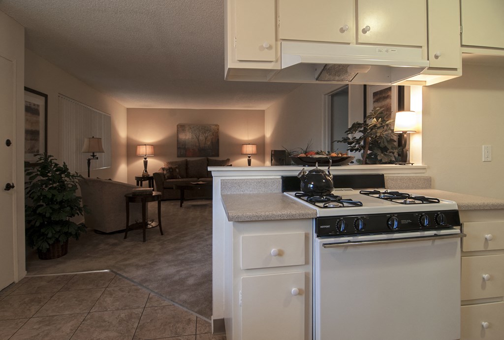 a kitchen with white cabinets and a white stove top oven