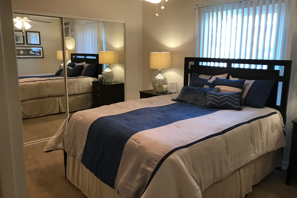 a bedroom with a bed and a mirror and a closet