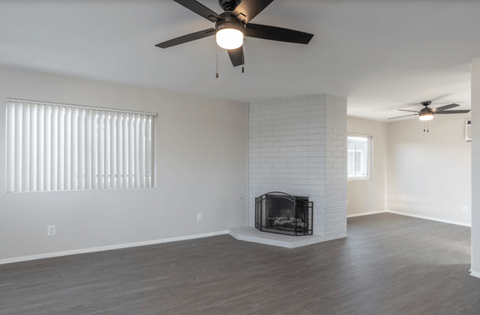 A room with a fireplace and a ceiling fan.