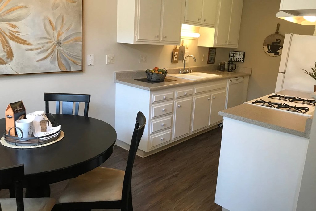 a kitchen with white cabinets and a black table
