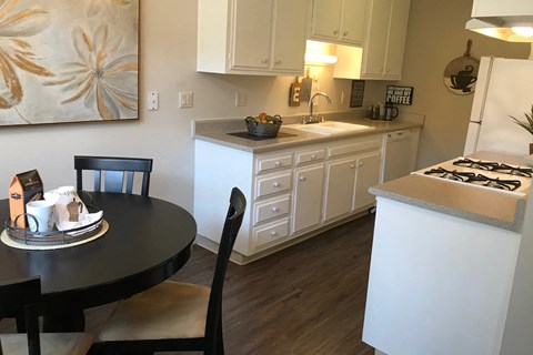 a kitchen with white cabinets and a table and a counter top