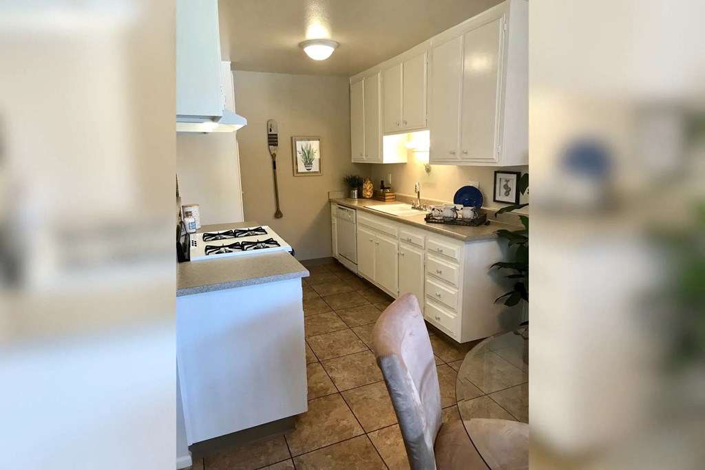 a kitchen with white cabinets and a stove and a sink