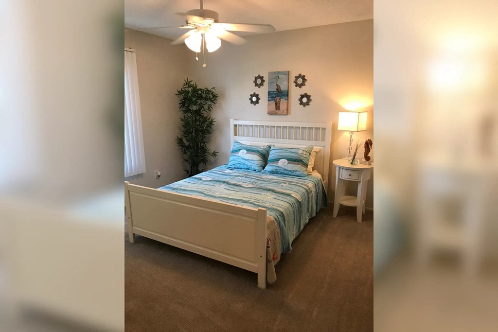 a bedroom with a bed and a ceiling fan