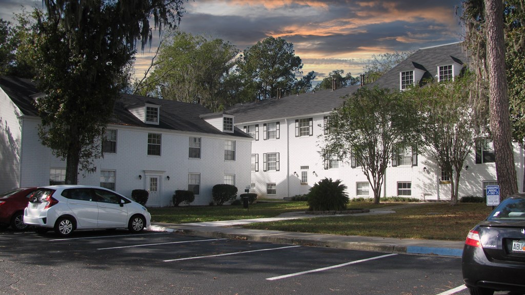 a car parked in a parking lot in front of a white building