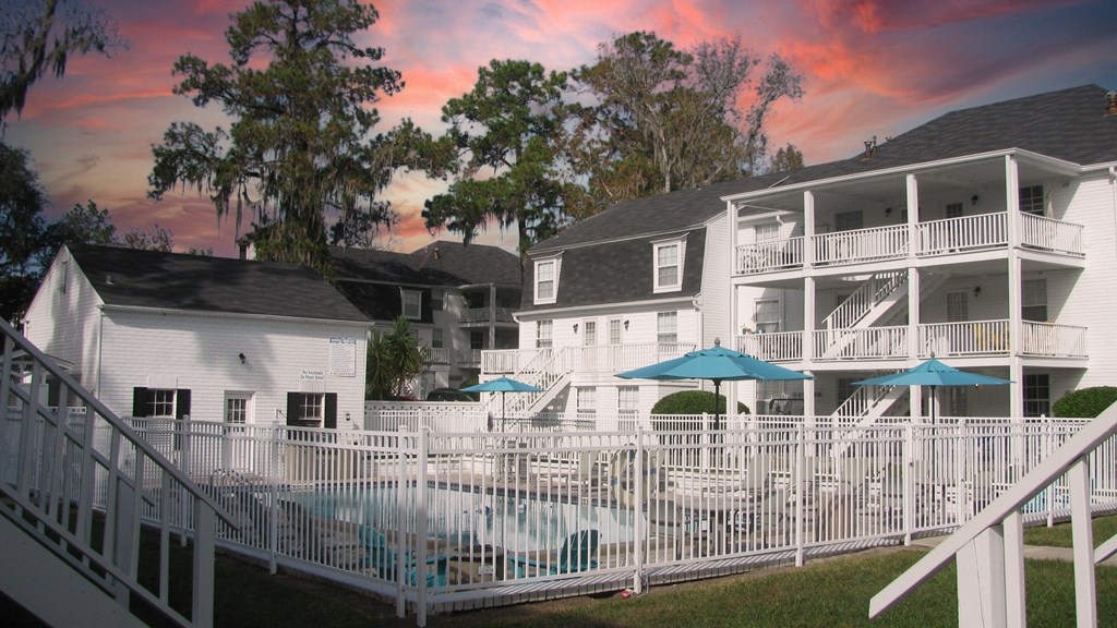 a large white building with a pool in front of it