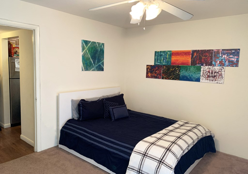 a bedroom with a bed and a ceiling fan