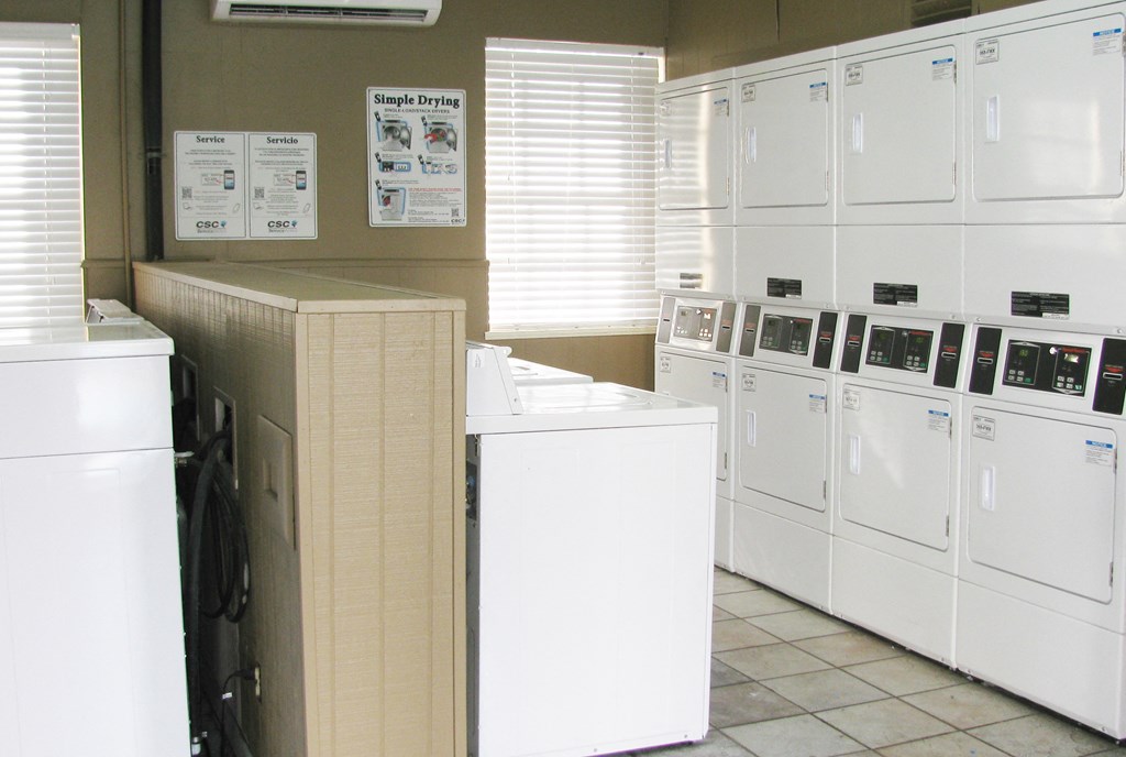 a laundry room with white washers and dryers