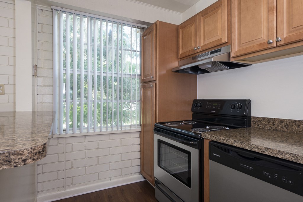 a kitchen with wood cabinets and a black stove top oven