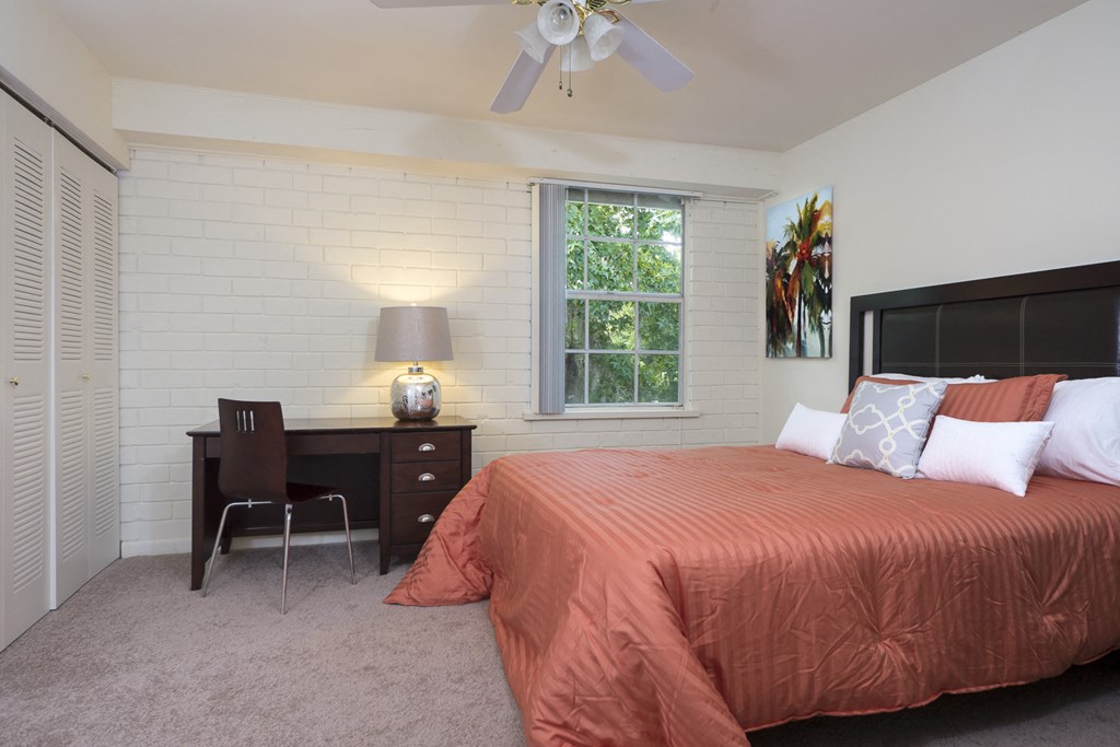 a bedroom with a bed and a desk